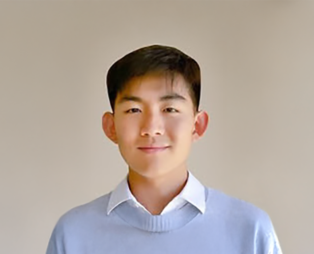 A color photo of a man smiling for a portrait.