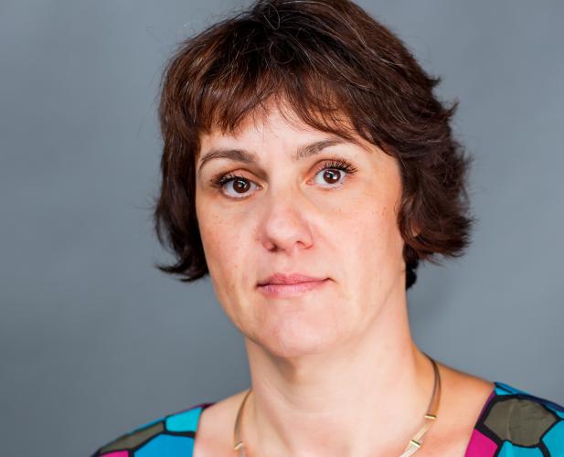 Color photo of woman with chin length brown hair