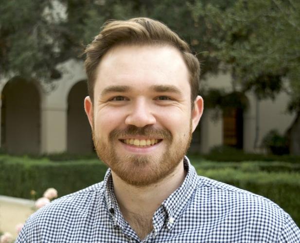 Color portrait Preston Culbertson smiling at the camera; short brown hair wearing checker shirt