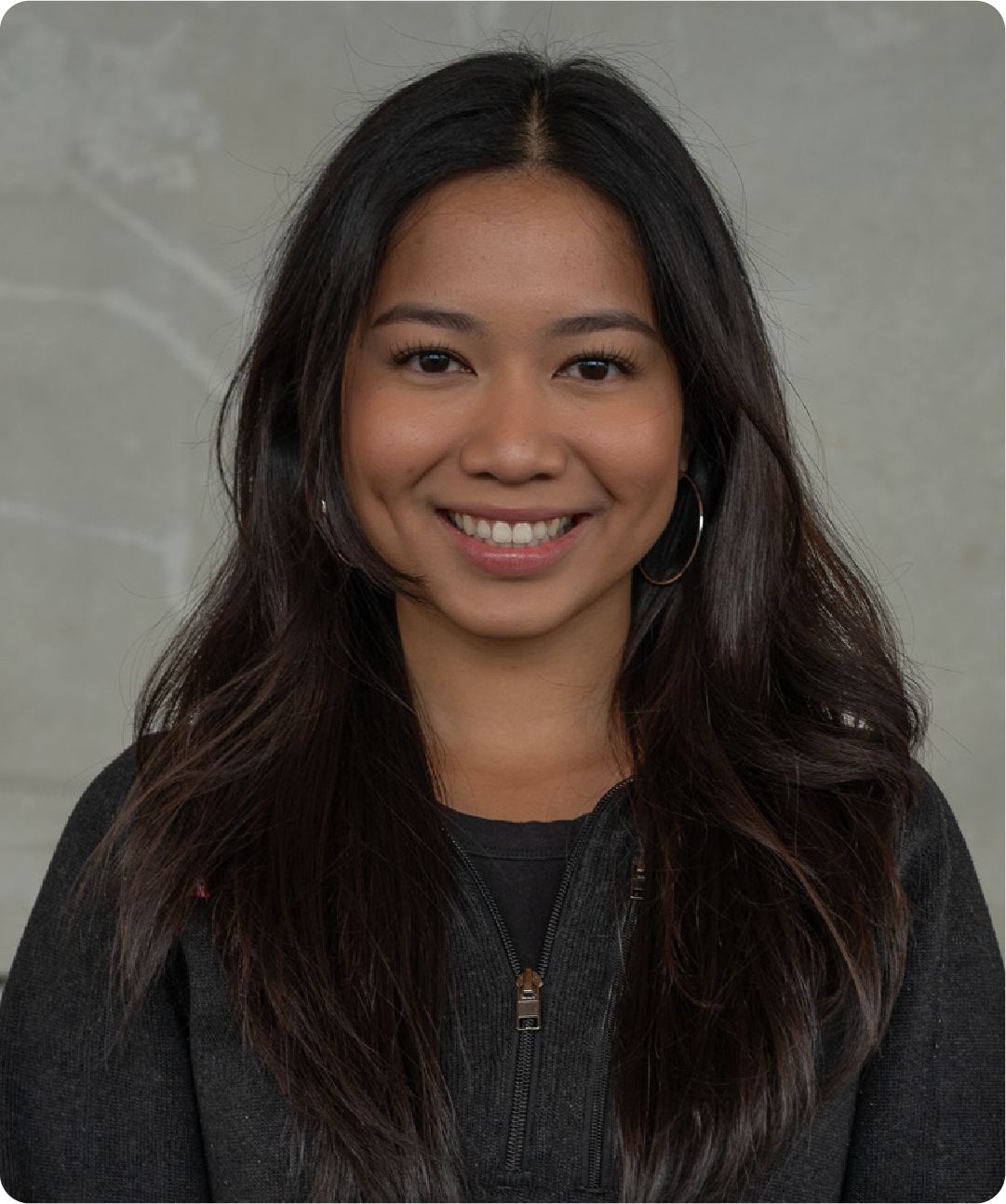 A color photo of a woman smiling for a photo.