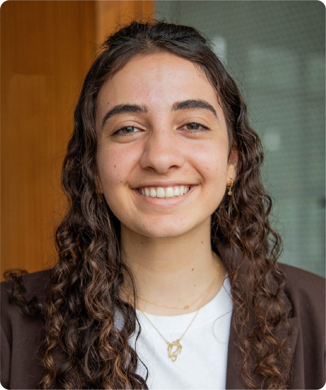 A color photo of a woman smiling for a photo.