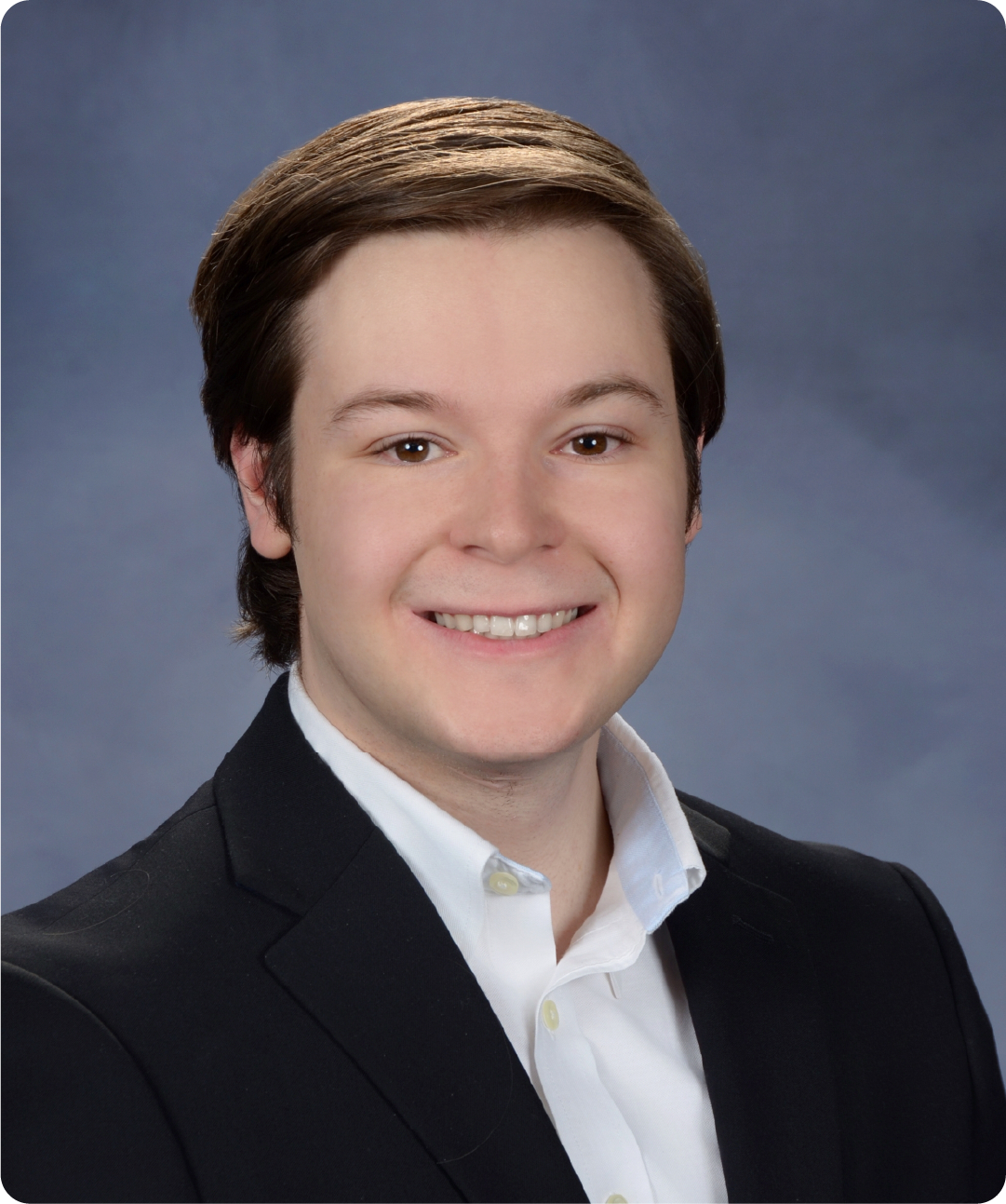 A color photo of a man smiling for a portrait.