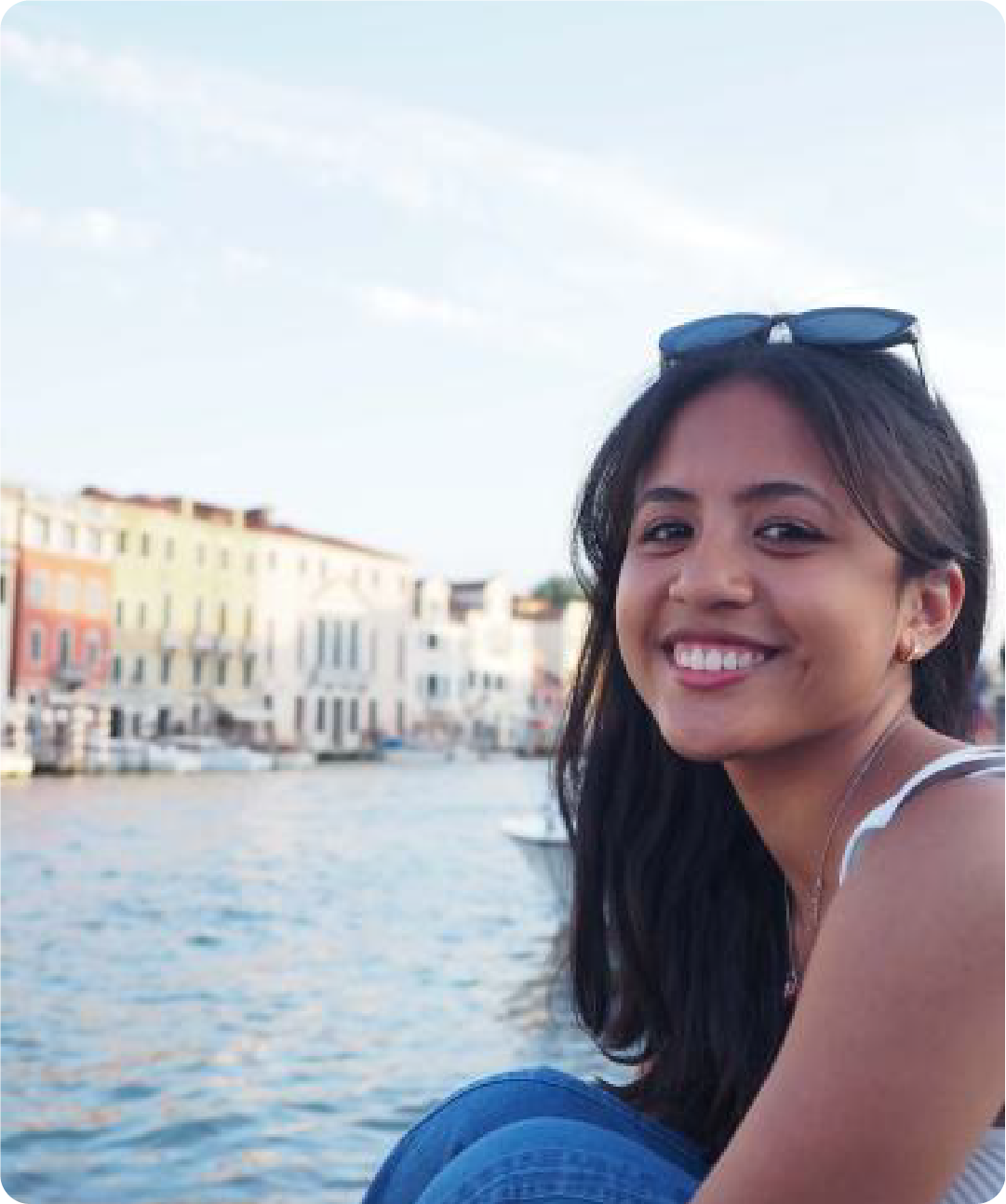 A color photo of a woman smiling for a photo in Italy.