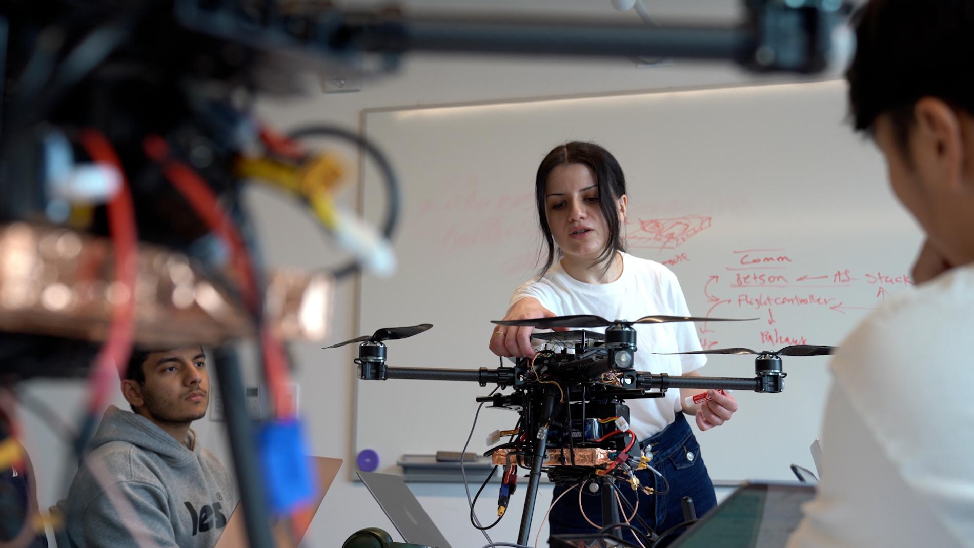 A color photo of a woman working on a drone.